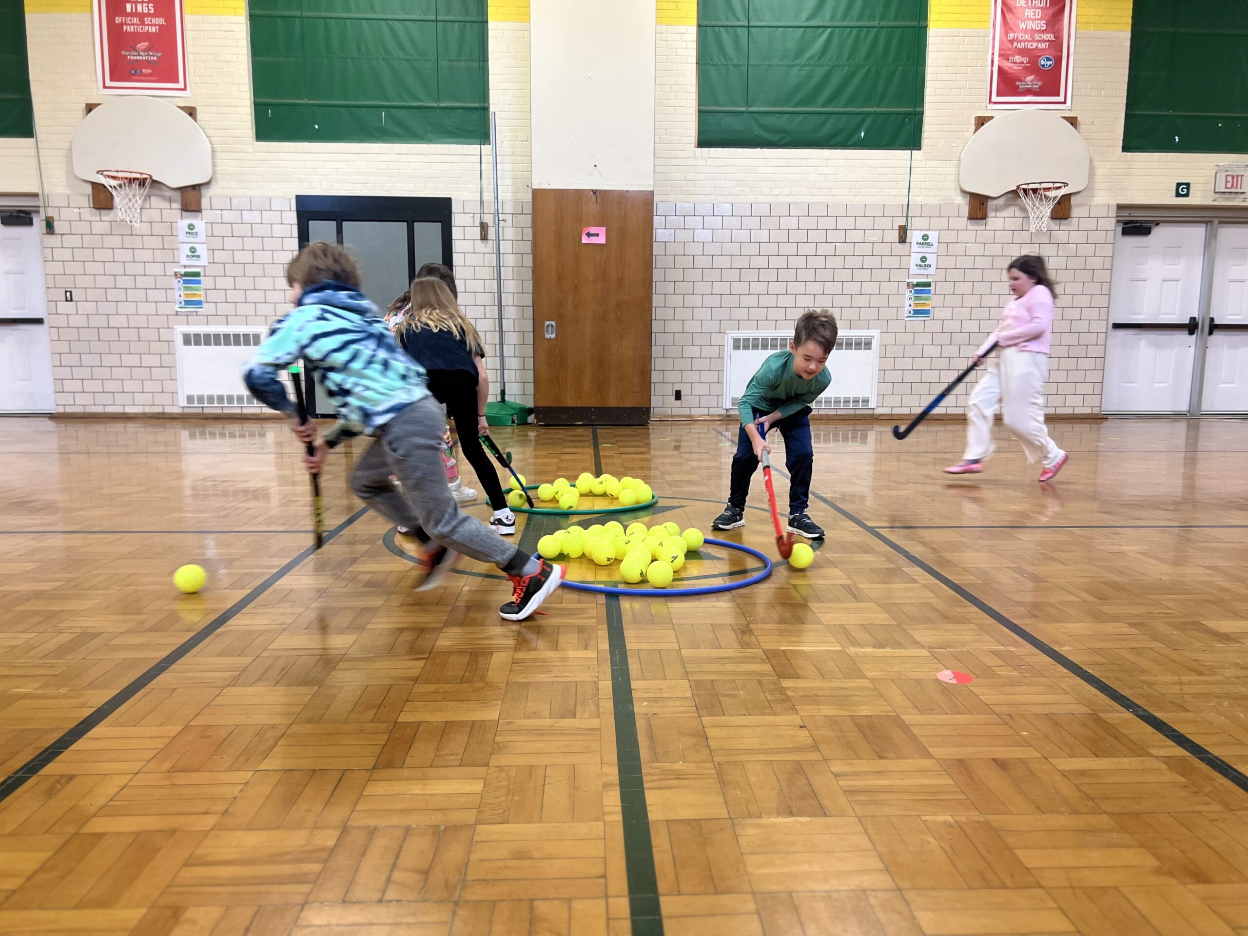 action photo from co-ed youth indoor field hockey during gym class