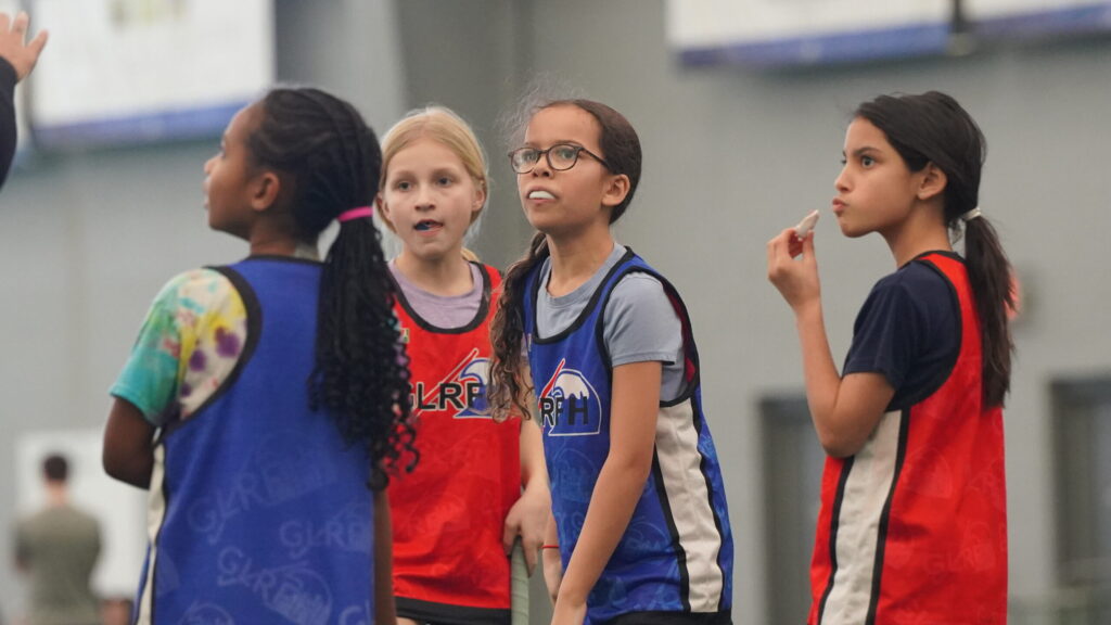 group of youth field hockey players listening during youth program